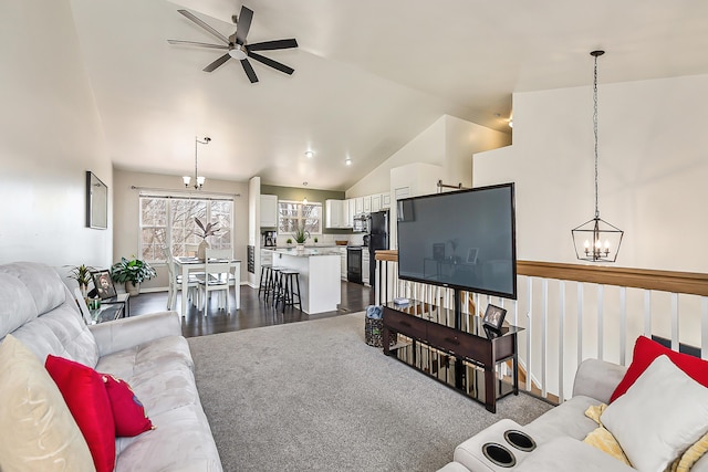 living room featuring dark wood-style floors, ceiling fan with notable chandelier, and high vaulted ceiling