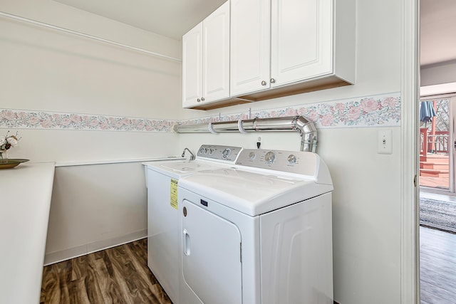 washroom featuring cabinet space, dark wood-style flooring, and washer and clothes dryer