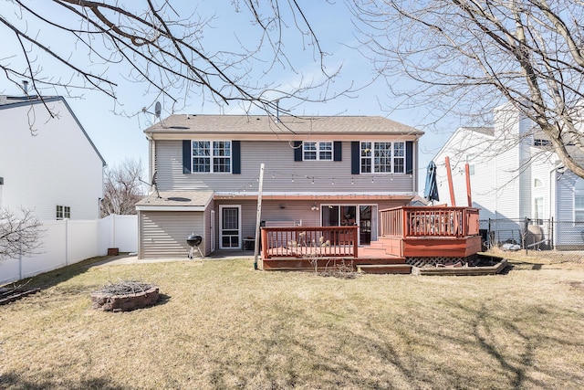 back of property with a wooden deck, a fenced backyard, a lawn, and an outdoor fire pit