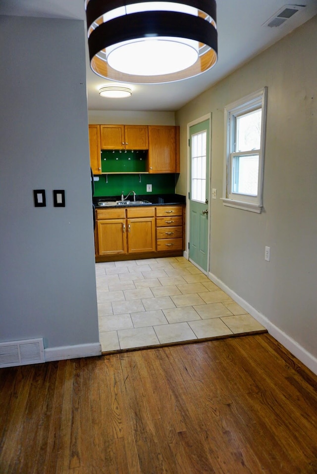 kitchen featuring dark countertops, visible vents, brown cabinets, and light wood-style floors