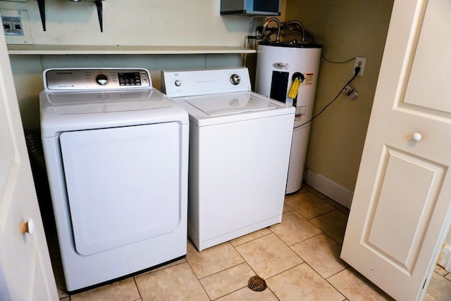 laundry room with laundry area, washing machine and clothes dryer, light tile patterned floors, and electric water heater