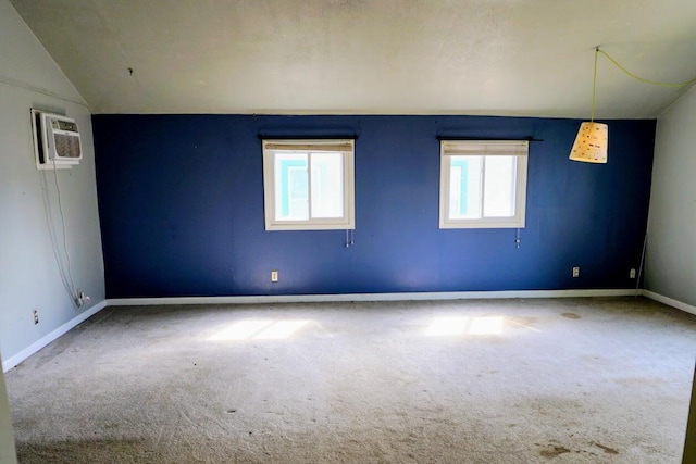 carpeted empty room with lofted ceiling, baseboards, and a wall mounted AC