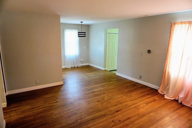 unfurnished room with dark wood-style floors and baseboards