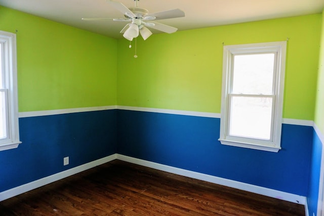 spare room featuring dark wood-type flooring, baseboards, and ceiling fan