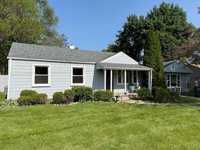 8876 Sheldon Rd, Plymouth, MI 48170 - view of front facade with covered porch, a front yard, roof with shingles, and a chimney