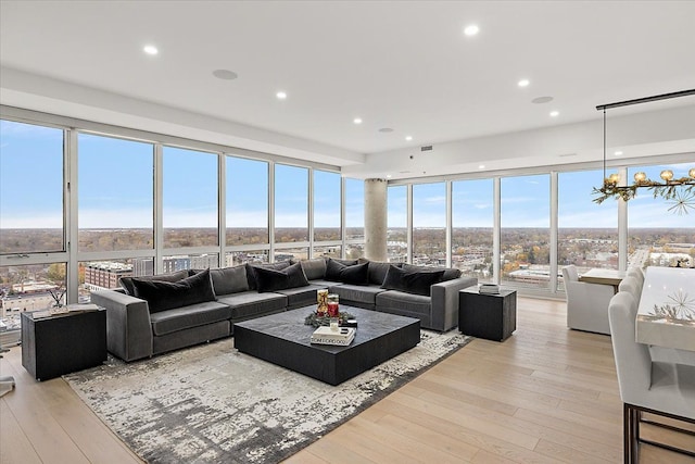 living room with recessed lighting, floor to ceiling windows, and light wood-style floors