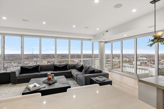 living area with visible vents, recessed lighting, light wood-type flooring, and expansive windows