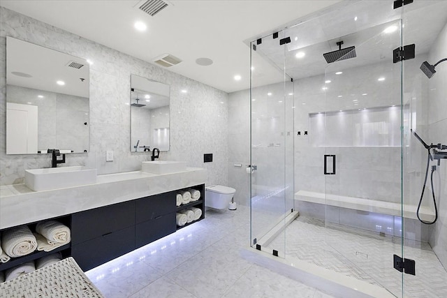 bathroom featuring a stall shower, visible vents, and a sink