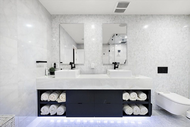 bathroom featuring double vanity, visible vents, tile walls, and a sink