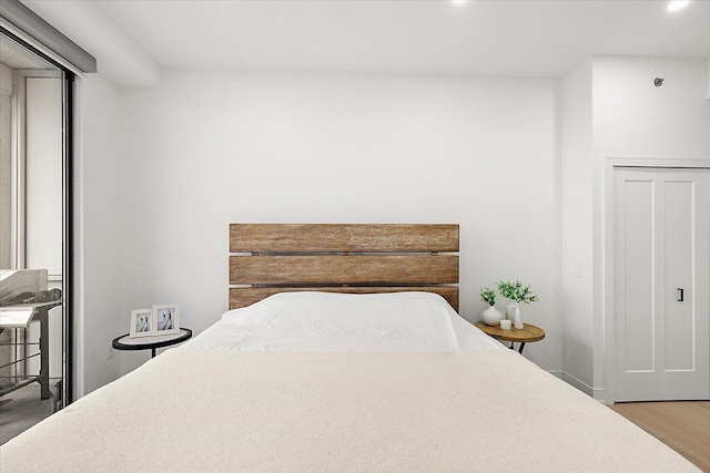 bedroom with recessed lighting and wood finished floors