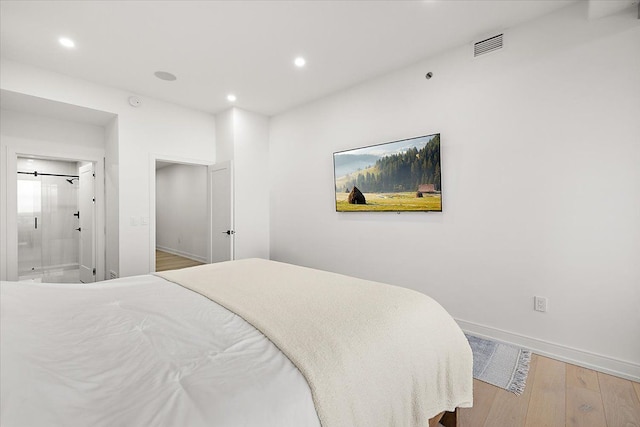 bedroom featuring visible vents, baseboards, recessed lighting, ensuite bathroom, and wood finished floors