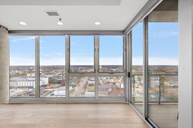 unfurnished sunroom with visible vents and a city view