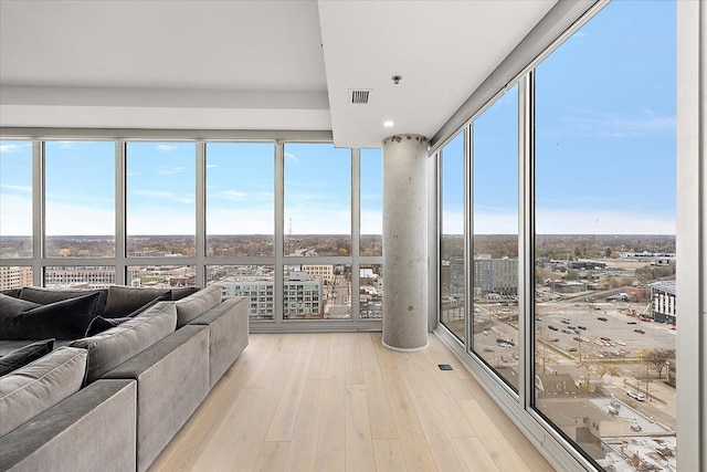 sunroom / solarium featuring visible vents, plenty of natural light, and a view of city