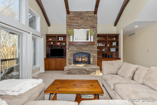 living area with beam ceiling, visible vents, a fireplace, and high vaulted ceiling