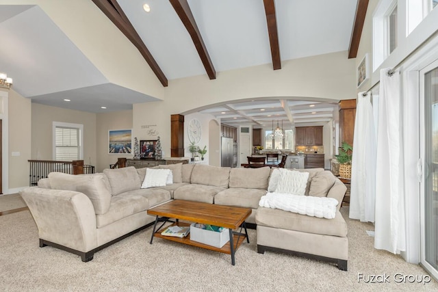 living room featuring arched walkways, high vaulted ceiling, beam ceiling, and a chandelier