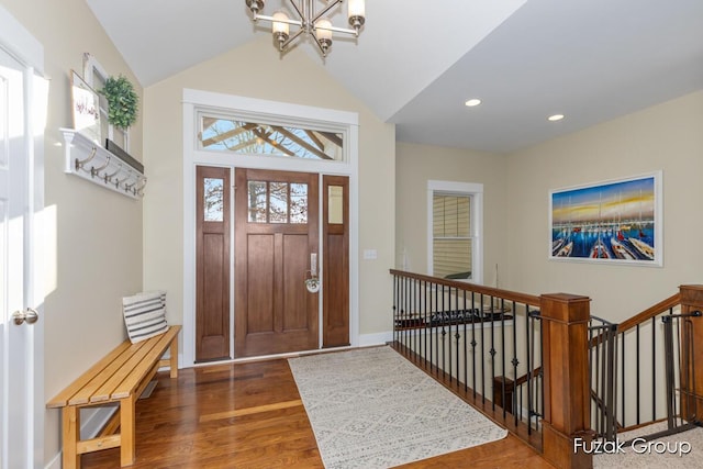 foyer featuring a notable chandelier, wood finished floors, recessed lighting, baseboards, and vaulted ceiling