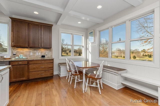 kitchen with beam ceiling, light stone counters, tasteful backsplash, coffered ceiling, and light wood finished floors