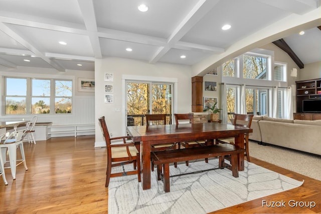 dining room with a wealth of natural light, beamed ceiling, and light wood-style flooring