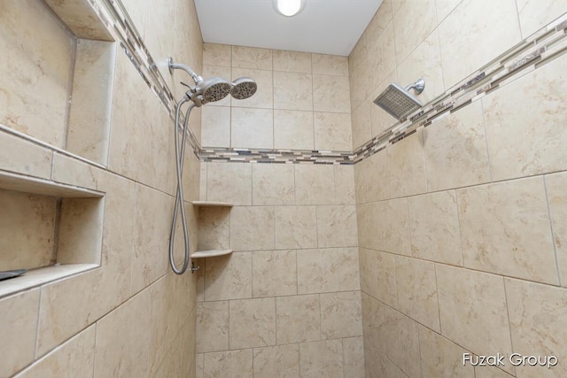 interior details featuring tiled shower