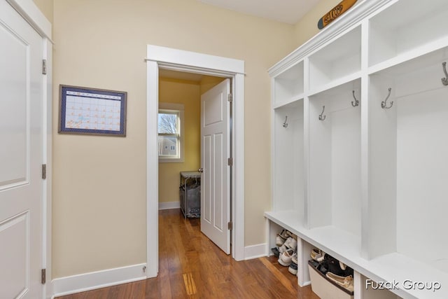 mudroom featuring baseboards and dark wood-style floors