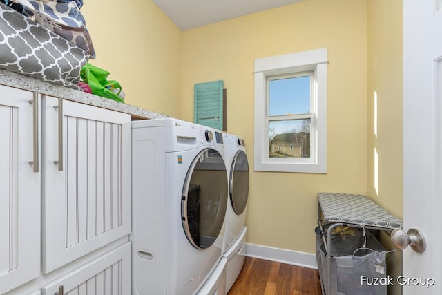 washroom with baseboards, separate washer and dryer, dark wood-style floors, and laundry area