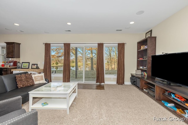 carpeted living room with recessed lighting, visible vents, and baseboards