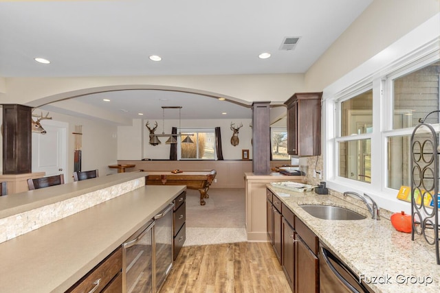 kitchen featuring arched walkways, visible vents, recessed lighting, and a sink