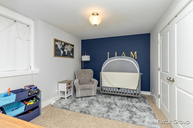 bedroom with an accent wall, baseboards, and carpet floors