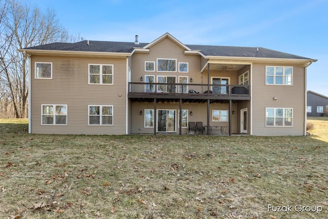 rear view of house with a yard, a deck, and a ceiling fan