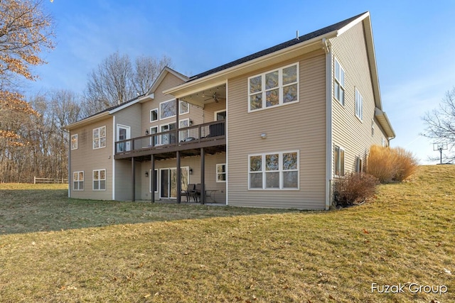 back of property with a ceiling fan, a lawn, and a wooden deck