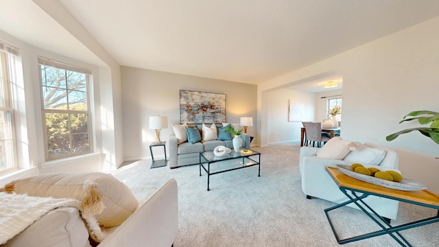 living room with baseboards and light colored carpet