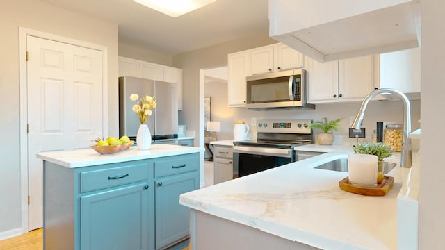 kitchen with a sink, light countertops, white cabinetry, and stainless steel appliances