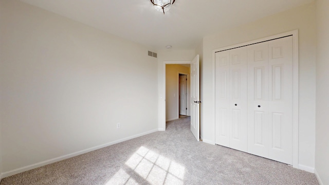 unfurnished bedroom with a closet, visible vents, baseboards, and carpet