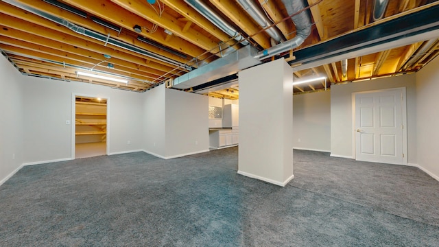 finished basement featuring dark carpet and baseboards