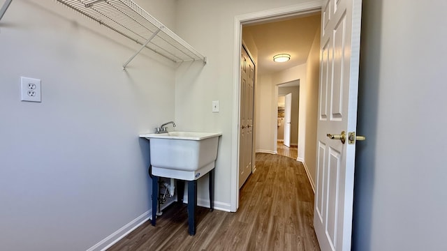 washroom with baseboards and dark wood-style flooring