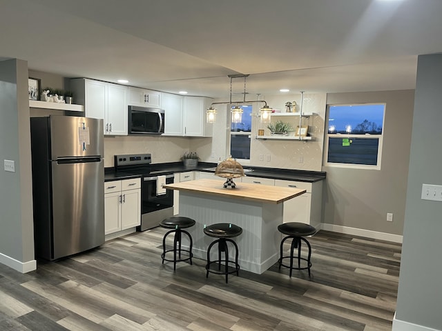 kitchen with white cabinets, appliances with stainless steel finishes, butcher block counters, and open shelves