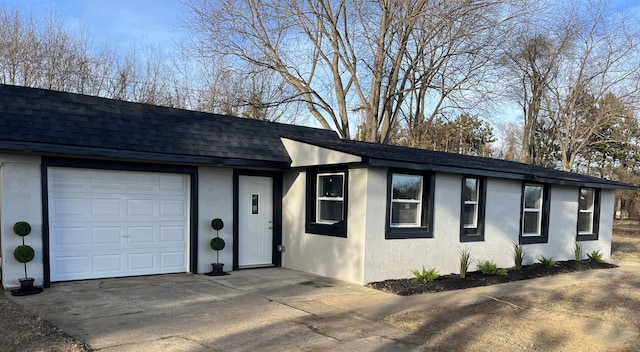 view of front of home with driveway, roof with shingles, and stucco siding