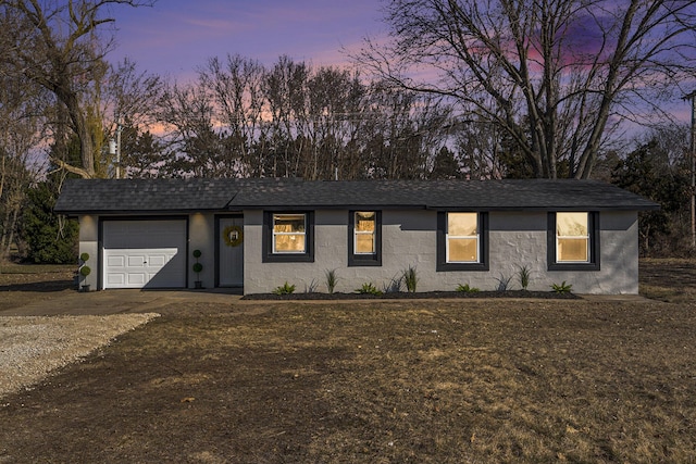 ranch-style home with an attached garage, driveway, roof with shingles, and stucco siding