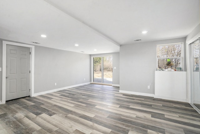 empty room featuring visible vents, recessed lighting, baseboards, and wood finished floors