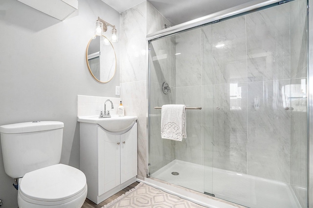 full bathroom with a shower stall, vanity, toilet, and wood finished floors