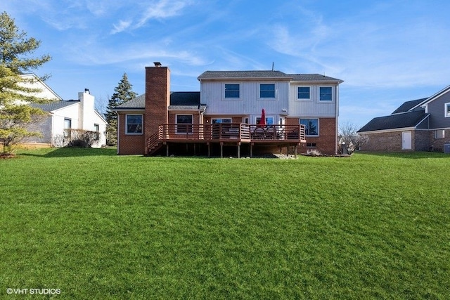 rear view of house featuring brick siding, a lawn, a chimney, and a wooden deck