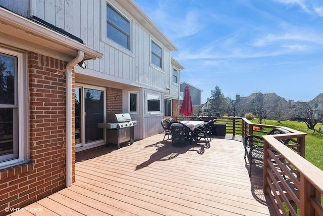 wooden terrace with outdoor dining area and area for grilling