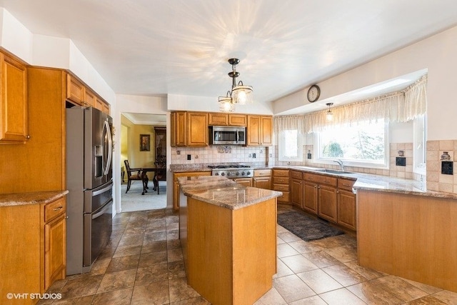 kitchen with a sink, backsplash, a kitchen island, and appliances with stainless steel finishes