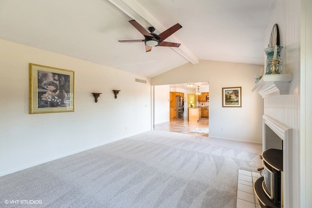 unfurnished living room with a ceiling fan, vaulted ceiling with beams, light colored carpet, and visible vents