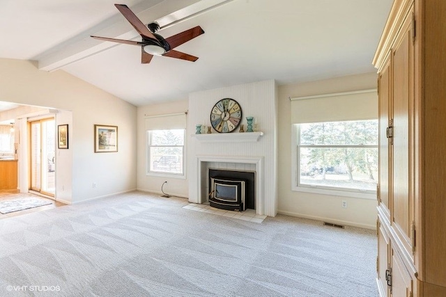 unfurnished living room featuring visible vents, lofted ceiling with beams, light carpet, a wood stove, and a ceiling fan