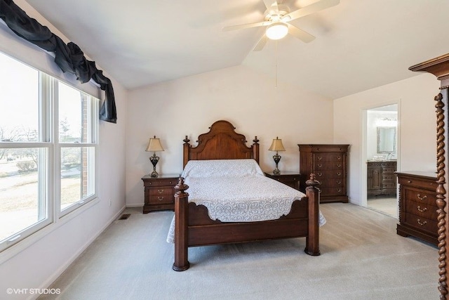 bedroom with visible vents, light carpet, a ceiling fan, ensuite bath, and vaulted ceiling