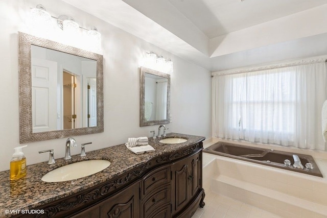 full bathroom with a garden tub, double vanity, and a sink