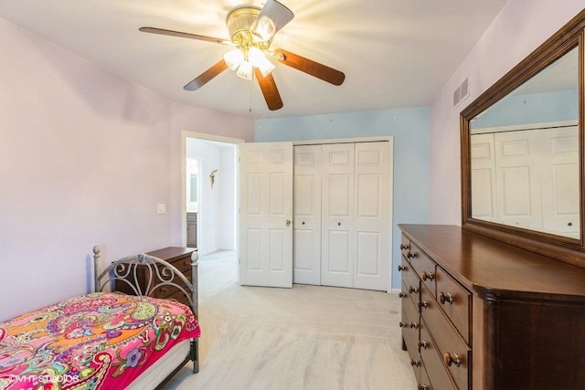 bedroom with visible vents, light colored carpet, a closet, and ceiling fan