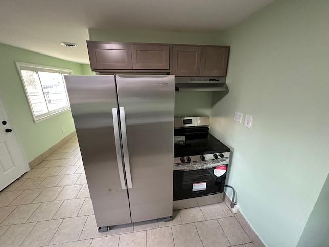 kitchen with visible vents, baseboards, under cabinet range hood, light tile patterned floors, and appliances with stainless steel finishes