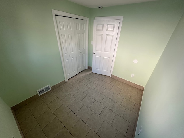 unfurnished bedroom featuring baseboards, visible vents, and a closet